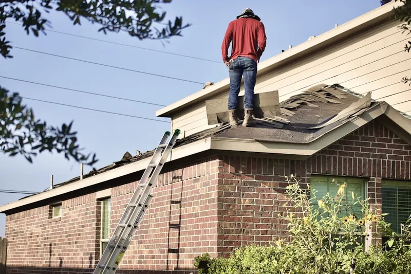 Professional roofer working on a residential roof in Harwood